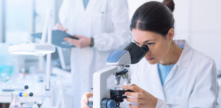 "Researcher Researcher looking into a microscope.