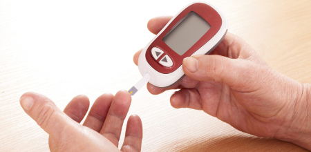 "Patient Patient using a blood glucose monitor to examine their blood sugar levels.